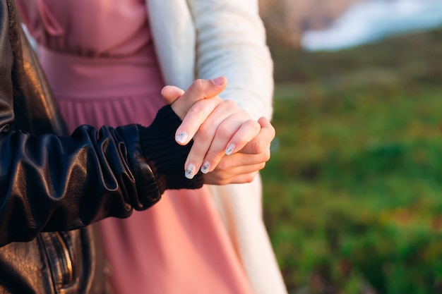 Primo piano della mano di un uomo che tiene la mano di una donna.