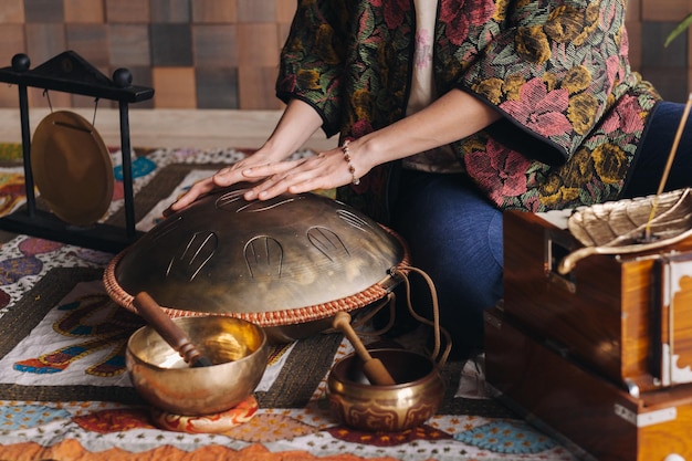 Primo piano della mano di una donna che suona uno strumento musicale moderno il tamburo a lamella di Orione