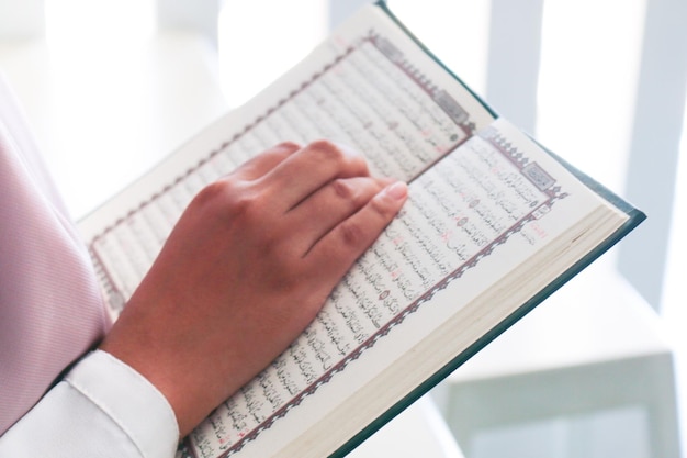 Primo piano della mano durante la lettura del Sacro Corano alla moschea Messa a fuoco selettiva