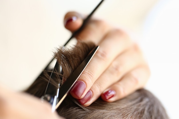 Primo piano della mano femminile che fa il taglio di capelli