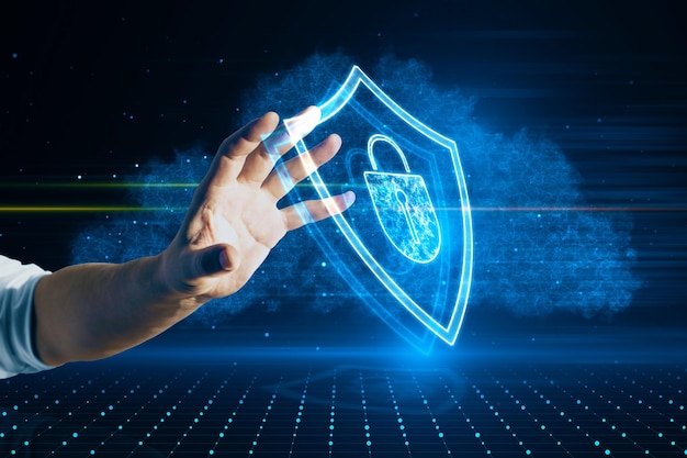 Primo piano della mano maschile che punta all'ologramma dello scudo luminoso su sfondo sfocato Protezione sicura sicurezza e concetto di sicurezza web