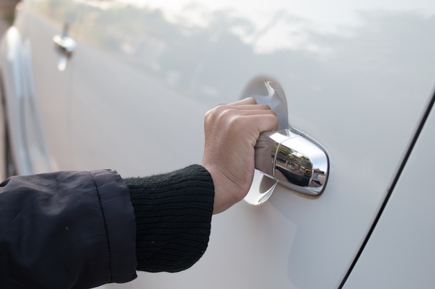 Primo piano della mano sta aprendo la porta dell&#39;auto