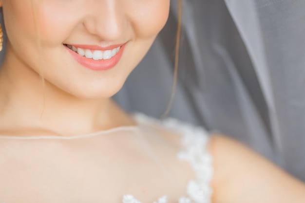 Primo piano della metà inferiore del viso della sposa con un sorriso carino