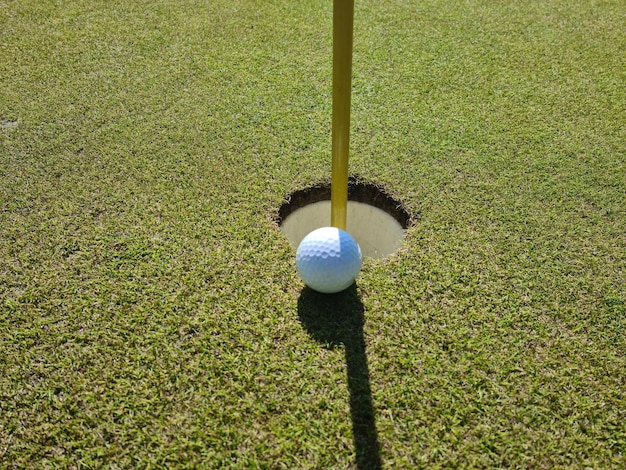 Primo piano della pallina da golf nel foro Giocare a golf