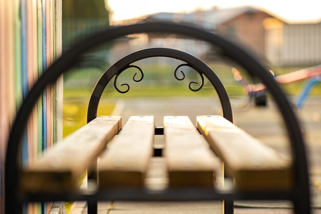 Primo piano della panchina del parco in legno con impugnatura in metallo all'aperto.