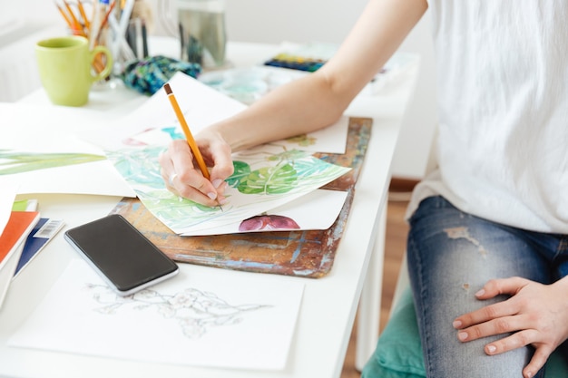 Primo piano della pittrice che disegna nello studio d'arte