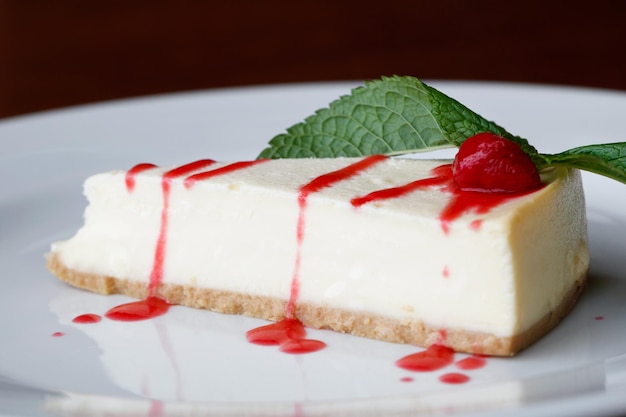 Primo piano della porzione cheesecake alla fragola su un piatto bianco