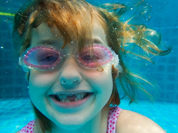 Primo piano della ragazza caucasica sott&#39;acqua in piscina