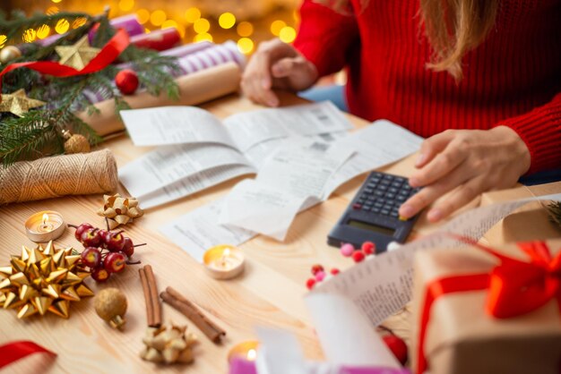 Primo piano della ragazza che guarda attraverso i controlli delle spese di Natale Controlli dai negozi per regali e decorazioni acquistati per Natale