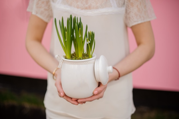 Primo piano della ragazza con i fiori in vaso di fiori