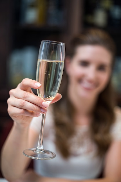 Primo piano della scanalatura di champagne felice della tenuta della donna