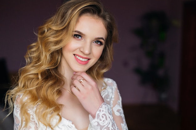 Primo piano della sposa che esamina la macchina fotografica sorridente bellissimo ritratto di trucco e acconciatura