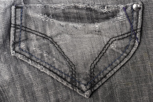 Primo piano della tasca dei jeans grigi su sfondo grigio dei jeans