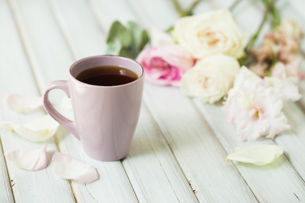 Primo piano della tazza di tè e delle rose