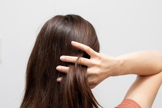 Primo piano della testa di una ragazza che tocca i suoi capelli per ripararlo