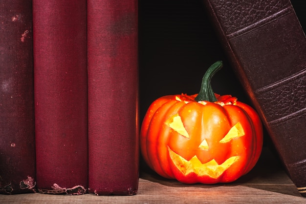 Primo piano della zucca di halloween tra vecchi libri