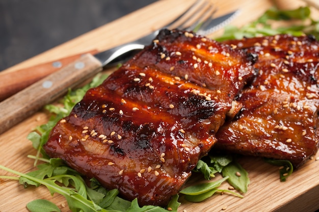 Primo piano delle costole di maiale grigliate con salsa barbecue.