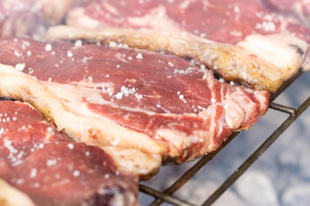 Primo piano delle cotolette al sale che cucinano sulla griglia del barbecue