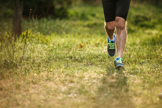 Primo piano delle gambe di un uomo che corre al mattino