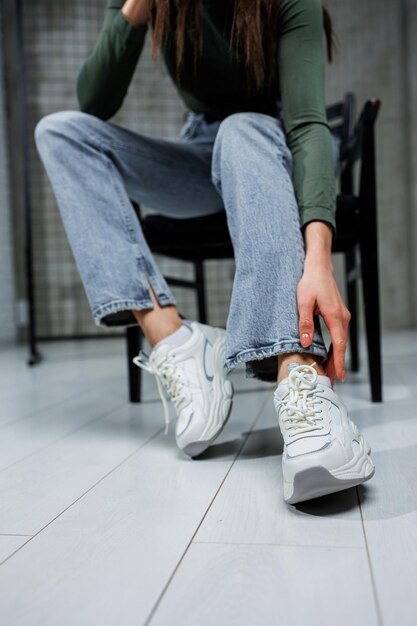 Primo piano delle gambe femminili in jeans e scarpe in primo piano sneakers alla moda Scarpe alla moda di tutti i giorni da donna