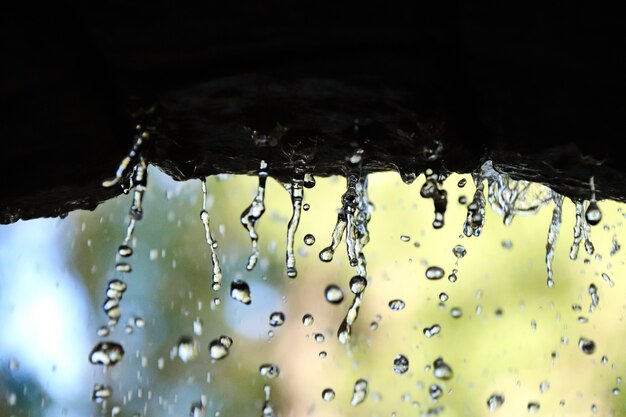 Primo piano delle goccioline d'acqua dallo sfondo sfocato dell'arco di pietra