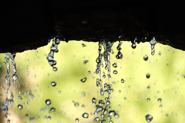 Primo piano delle goccioline d'acqua dallo sfondo sfocato dell'arco di pietra