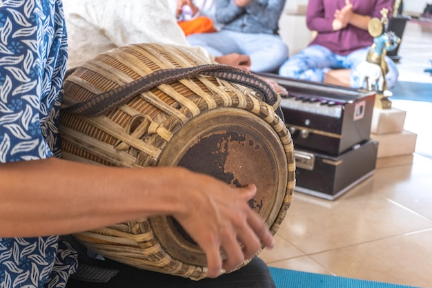 Primo piano delle mani che suonano un tamburo per la meditazione per cantare i mantra