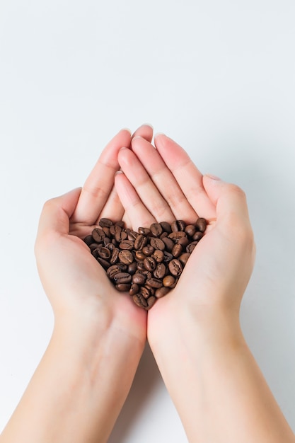 Primo piano delle mani con chicchi di caffè