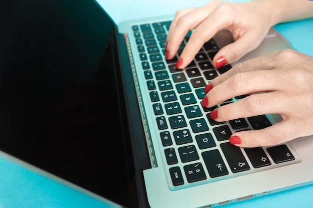 Primo piano delle mani con il computer portatile che digita sulla tastiera del computer portatile, il mondo della tecnologia e internet