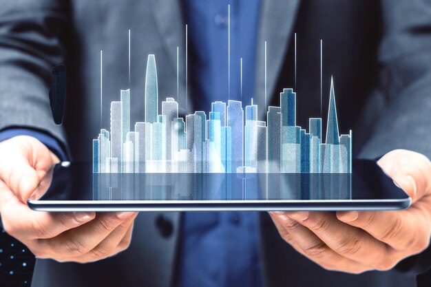 Primo piano delle mani dell'uomo che tengono il tablet con l'ologramma dello skyline della città incandescente astratto su sfondo tecnologico sfocato Metaverse innovazione e concetto di tecnologia