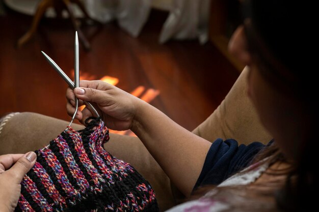 Primo piano delle mani della donna latino-americana che tengono un tipo di aghi circolari ideali per lavorare a maglia lunghe lunghezze in tondo con filati in materiale di lana Concetto hobby attività per il tempo libero