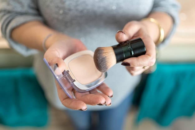 Primo piano delle mani della donna più anziana che maneggiano gli oggetti per il trucco