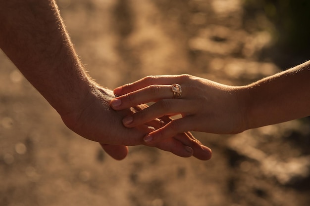 Primo piano delle mani della genteCoppia che si tiene per mano al tramonto