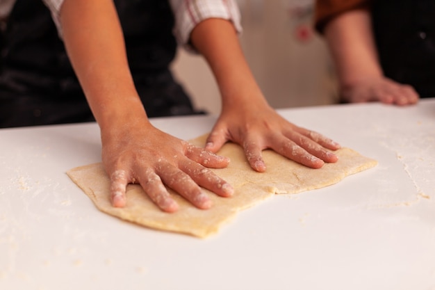 Primo piano delle mani della nipote che preparano il pan di zenzero fatto in casa