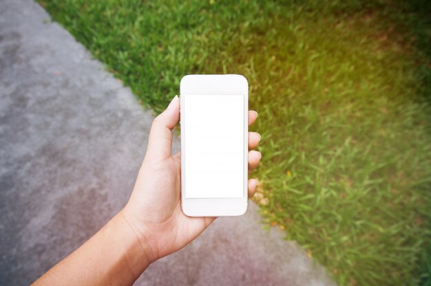 Primo piano delle mani delle donne in possesso di cellula telefono vuoto spazio copia dello schermo. telefono astuto con concetto di tecnologia.