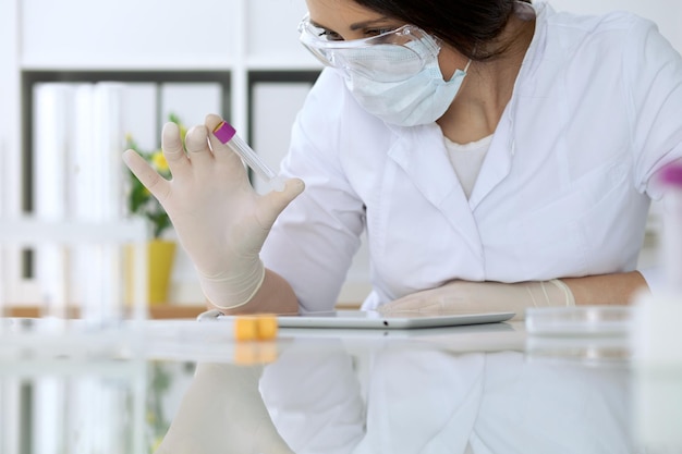 Primo piano delle mani di ricerca scientifica con una soluzione chiara in laboratorio.