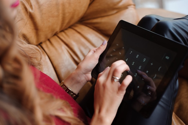 Primo piano delle mani di una giovane donna che lavora con il tablet