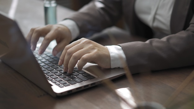 Primo piano delle mani femminili che lavorano al laptop