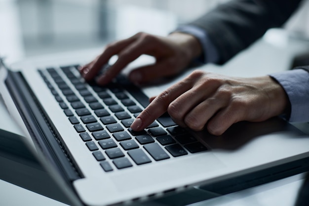 Primo piano delle mani maschili utilizzando il computer portatile in ufficio