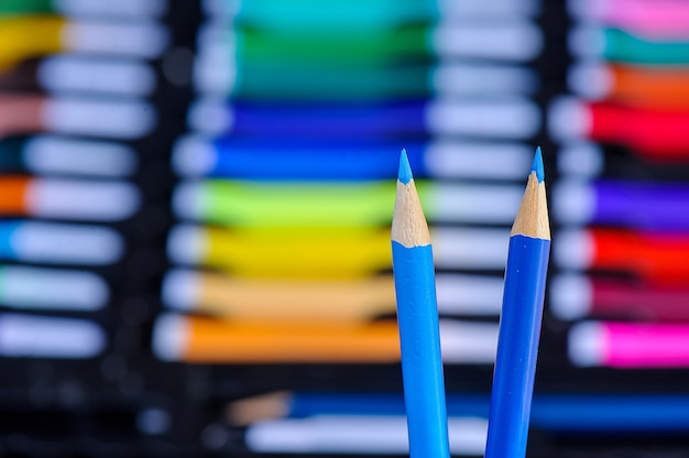 Primo piano delle matite di colore blu su sfondo multicolore