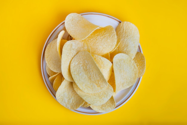 Primo piano delle patatine fritte, alimenti a rapida preparazione malsani. Sfondo giallo