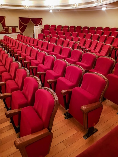 Primo piano delle tradizionali sedie vuote classiche rivestite in velluto rosso all'interno del teatro