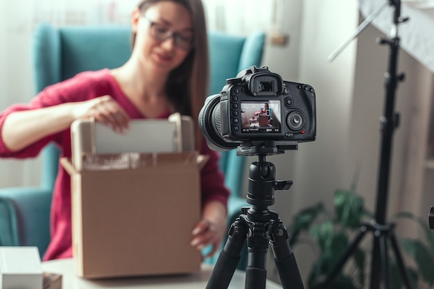 Primo piano dello schermo della fotocamera, la donna blogger fa il video del disimballaggio