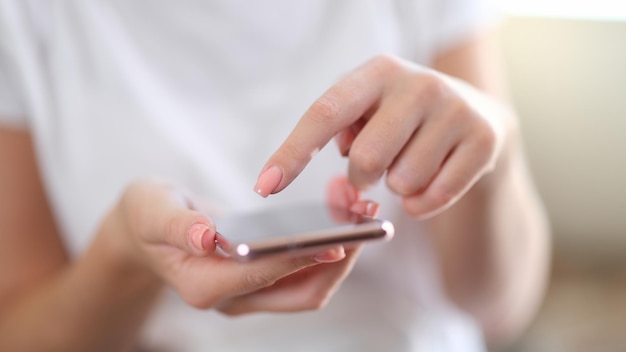 Primo piano dello smartphone nelle mani della donna che chiacchiera leggendo notizie e guardando video online