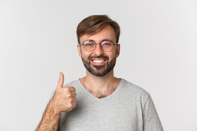 Primo piano di allegro uomo caucasico con barba, con gli occhiali e t-shirt casual