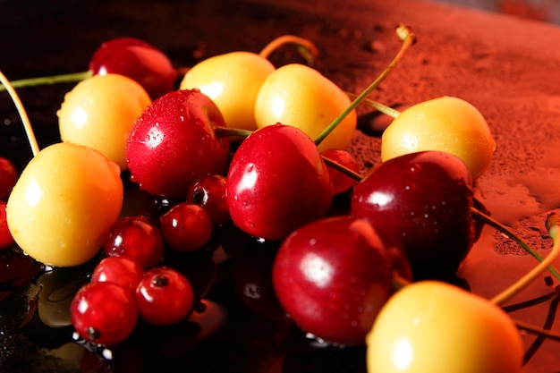 Primo piano di bacche dolci con gocce d'acqua su sfondo scuro Concetto di cibo sano