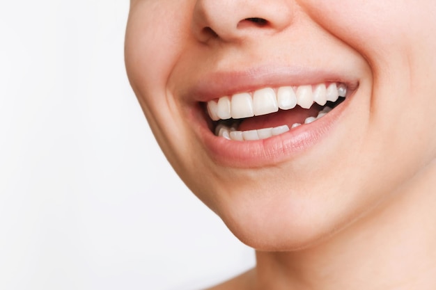 Primo piano di bel sorriso Ritagliata colpo di una giovane donna caucasica con denti bianchi perfetti anche