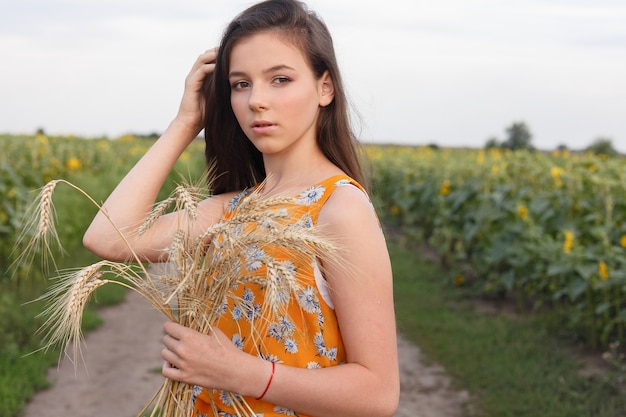 Primo piano di bella donna in vestito vicino al raccolto di grano wheat