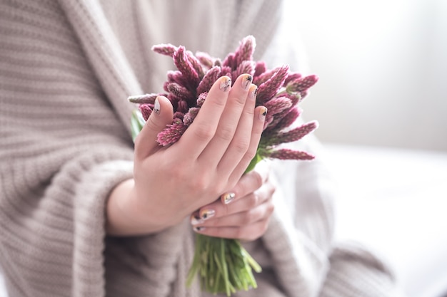 Primo piano di belle mani femminili che tengono i fiori