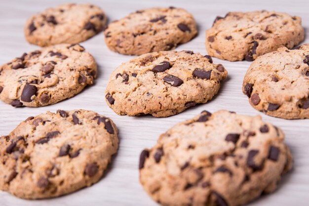 Primo piano di biscotti con gocce di cioccolato su sfondo tavolo in legno